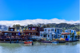 Artist-build houseboats on Richardson Bay, Sausalito, California, with summer fog on the hills to the west.